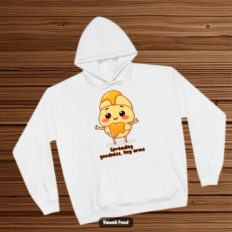 Funny hoodie depicting a happy croissant character with diminutive arms, joyfully spreading a thick layer of jam.